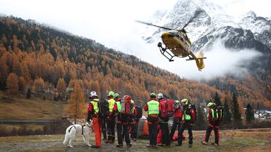Mitglieder der Bergrettung und ein Helikopter im Einsatz am Ortler