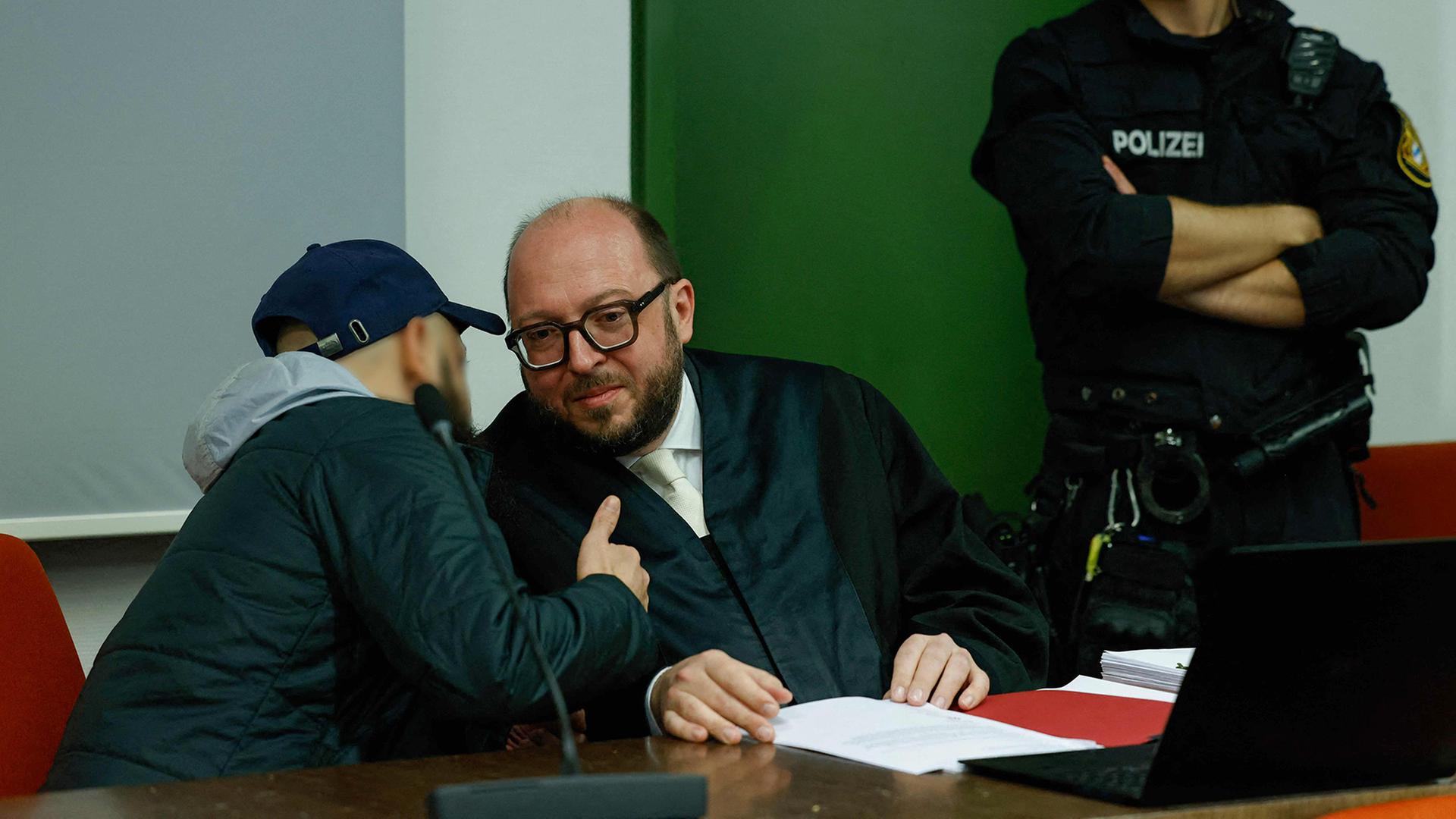 Der Angeklagte Dieter S. (links) spricht mit seinem Anwalt, während er vor Gericht in München auf sein Urteil wartet. | AFP