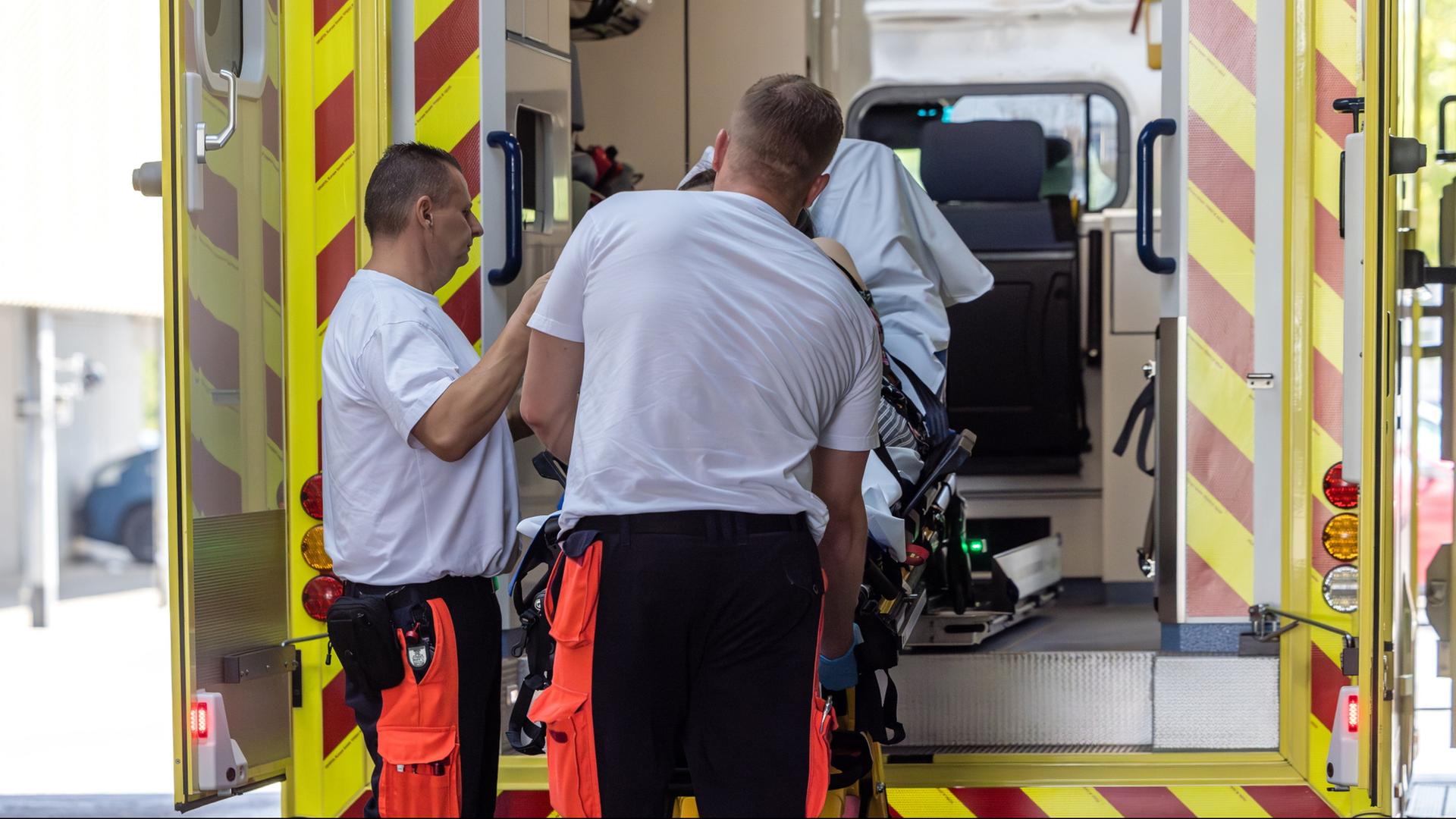 Rettungssanit�ter k�mmern sich um eine Patientin mit hitzebedingten Beschwerden. | dpa