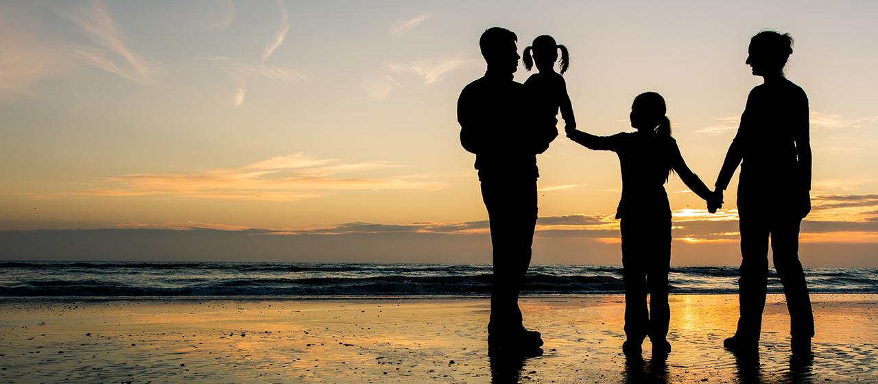 Silhouetten am Strand von Eltern mit zwei Töchtern