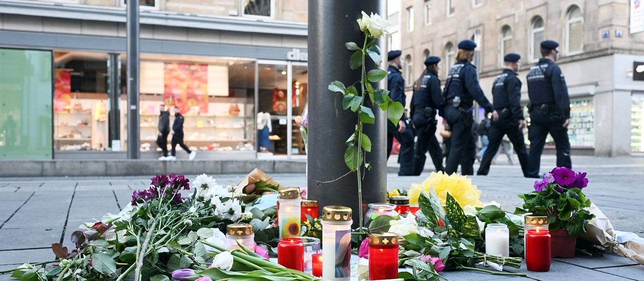 Kerzen und Blumen liegen in der Nähe des Paradeplatzes in Mannheim.