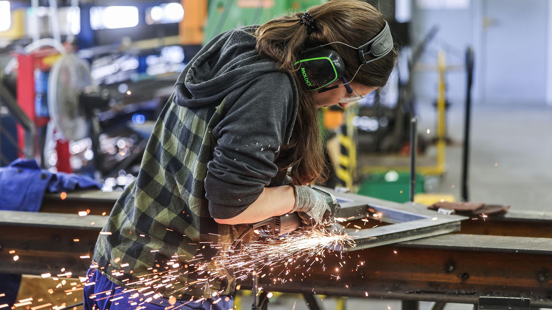 Eine Auszubildende zur Metallbauerin arbeitet im AusbildungsCampus Butzweilerhof in KÃ¶ln mit einem SchleifgerÃ¤t. | picture alliance/dpa