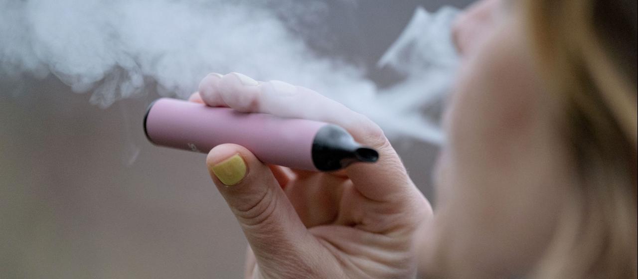 Eine Frau raucht eine Einweg-E-Zigarette