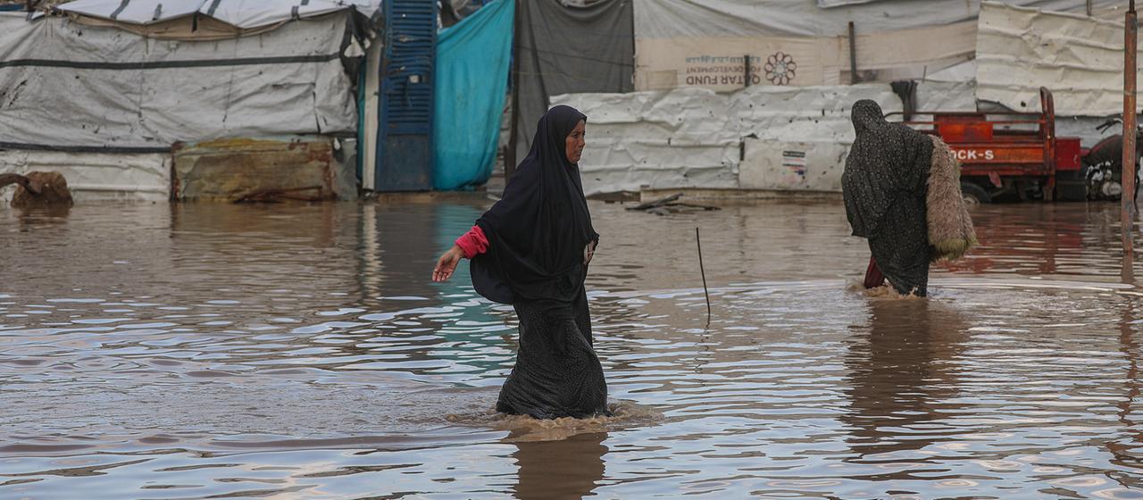 Palästinenser laufen im Stadtteil Al Zaitun im Osten von Gaza-Stadt im Gazastreifen durch überflutete Straßen.