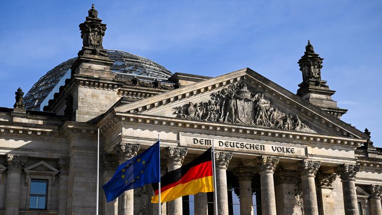 Flaggen wehen vor dem Reichstags-Gebäude, in dem der Bundestag sitzt.