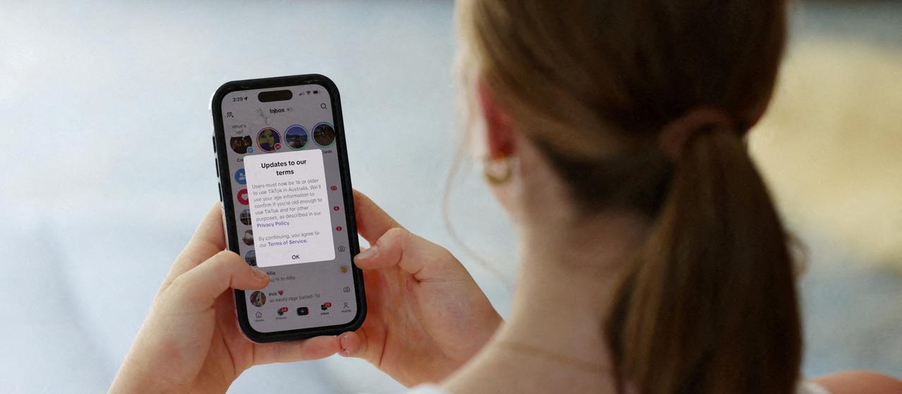 A teenager looks at her cell phone.