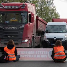 Klimaaktivisten blockieren eine Straße.