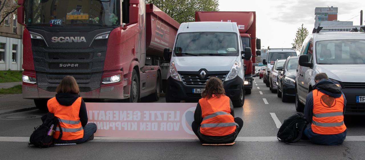 Klimaaktivisten blockieren eine Straße.