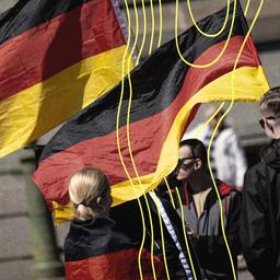 Menschen nehmen mit Deutschlandfahnen an einer Demo in Berlin Mitte teil.