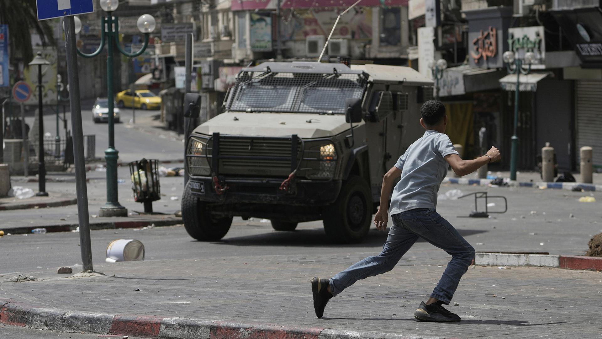 Ein Palästinenser rennt während Zusammenstößen mit israelischen Streitkräften durch eine Straße in Nablus. | AP