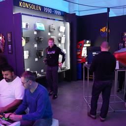 Gaming-Fans zocken an Spielekonsolen im Videospielemuseum