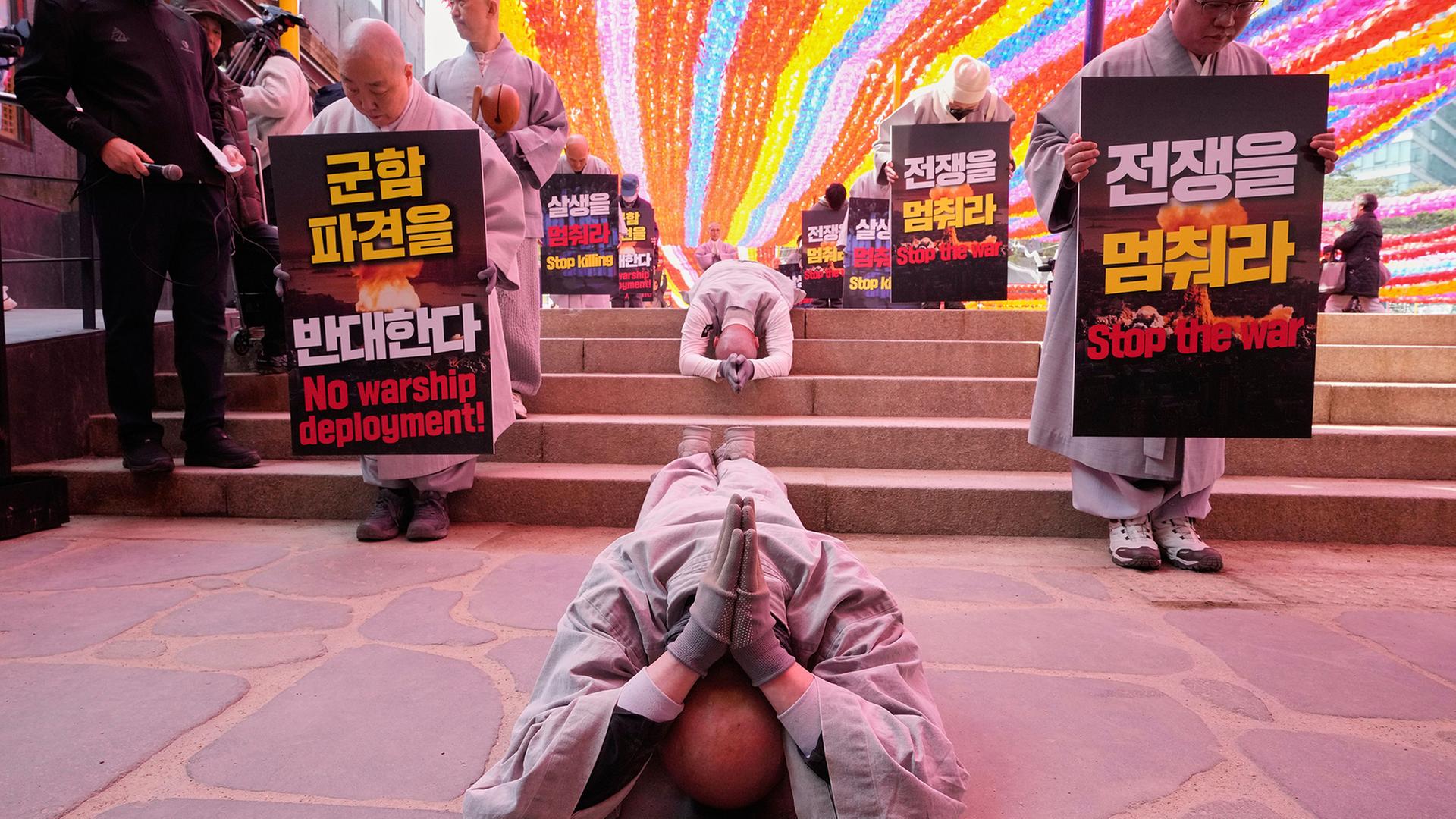 SÃ¼dkoreanische buddhistische MÃ¶nche verneigen sich und werfen sich auf der StraÃe nieder. | AP