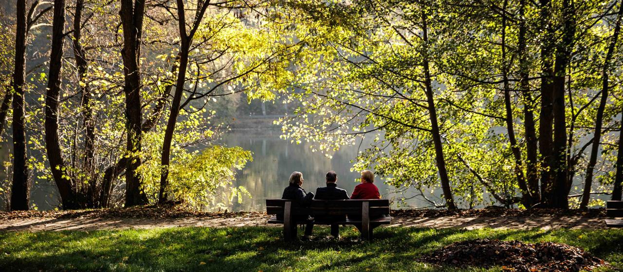 Menschen sitzen bei strahlender Herbstsonne am See in Lanke bei Wandlitz.