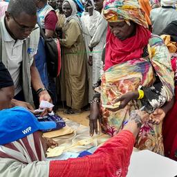 Geflüchtete stehen in einem Flüchtlingscamp an der Grenze zwischen Sudan und Tschad in einer Schlange für Lebensmittel