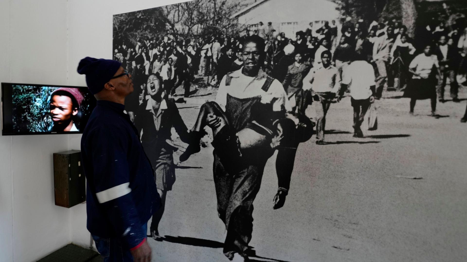 Ein Mann betrachtet ein Bild des Soweto-Aufstands. | AP Photo/Themba Hadebe