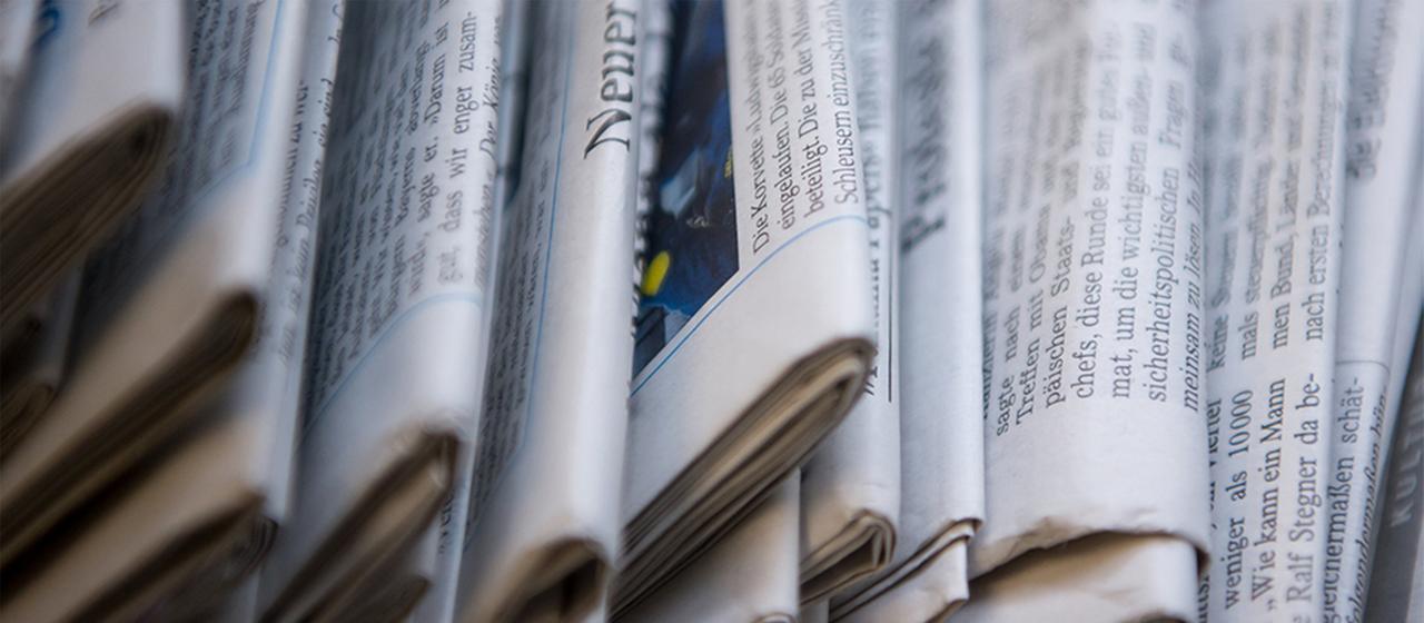 Ein Stapel mit verschiedenen Tageszeitungen liegt auf einem Tisch