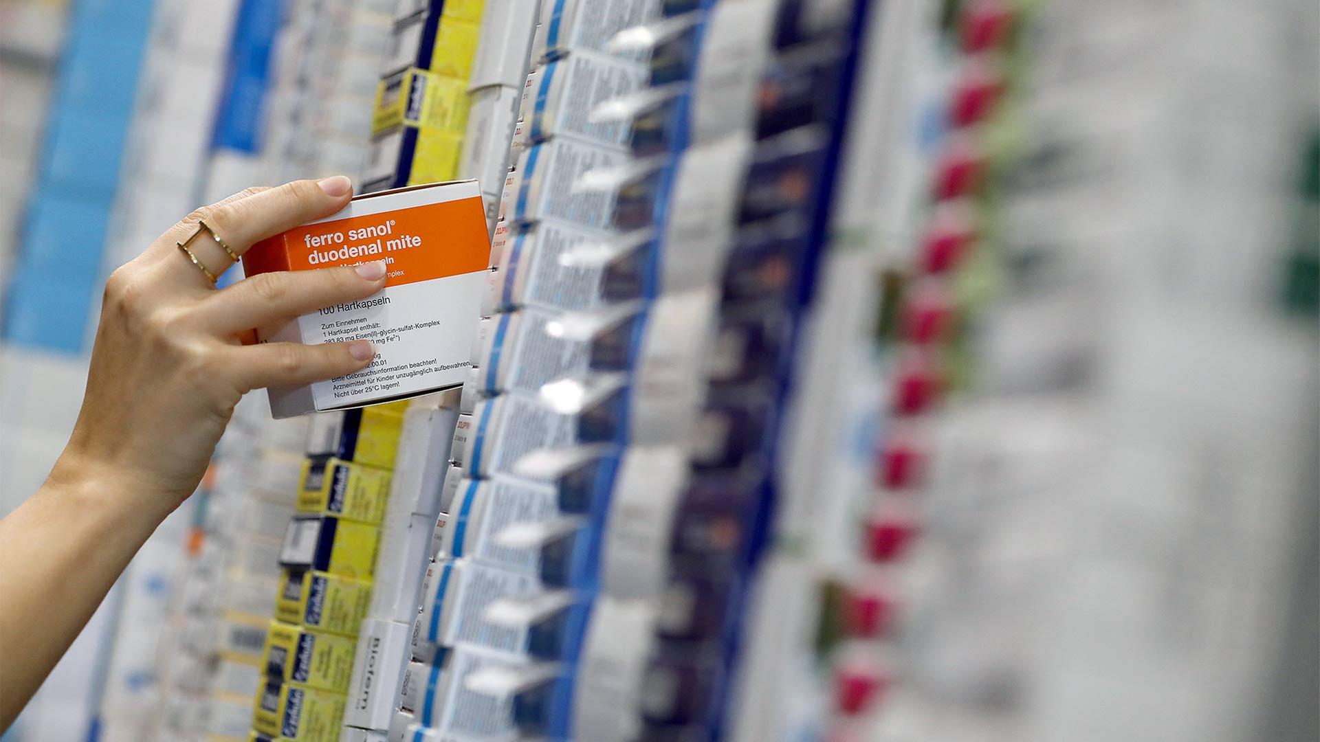 Eine Frau sortiert im Logistik Zentrum einer Versandapotheke Medikamente. | picture alliance/dpa