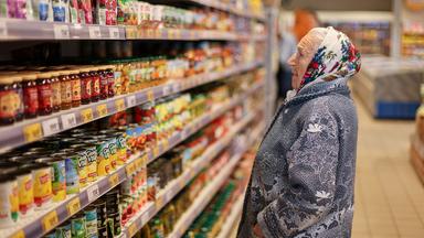 Eine Kundin steht in einem russischen Supermarkt vor einem Regal.