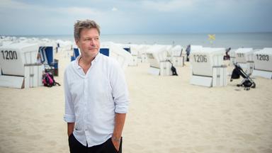 Robert Habeck an einem Strand mit Strandkörben.
