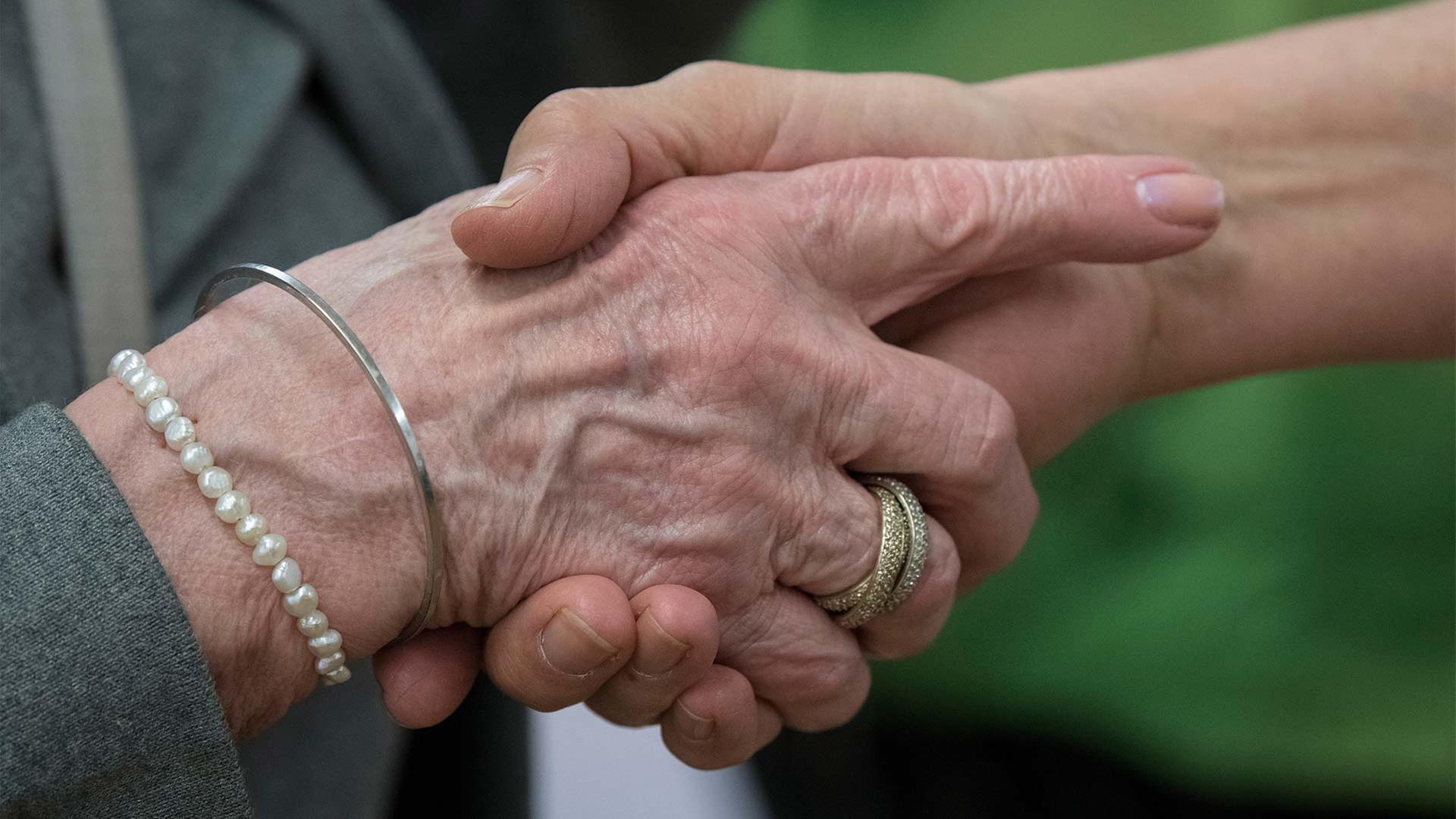 Hand einer alten und einer jüngeren Person. | picture alliance / Boris Roessle