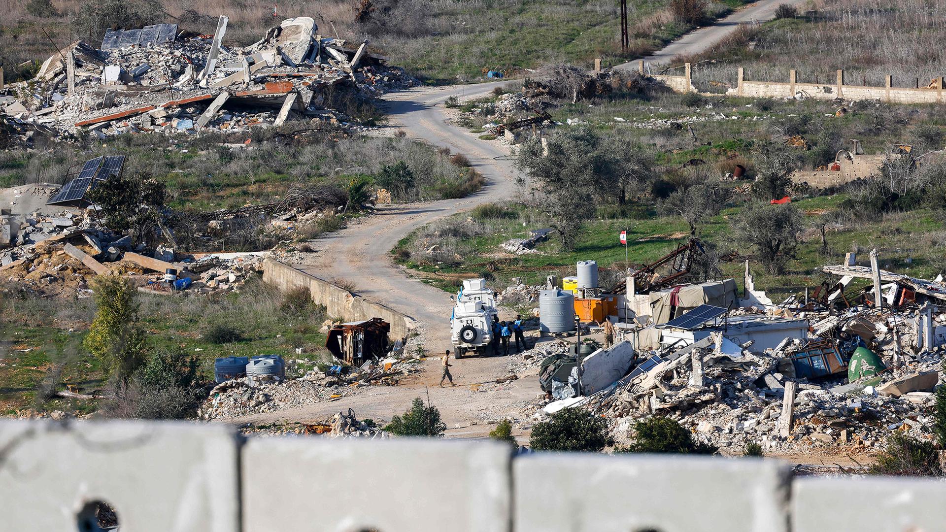 UN-Friedenstruppen der UNIFIL sind zusammen mit libanesischen Soldaten neben zerstörten Gebäuden und Autos im südlibanesischen Dorf Dhayra zu sehen. | AFP