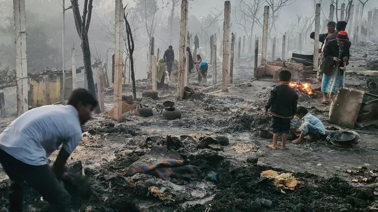 Menschen suchen nach dem Brand im Flüchtlingscamp Ukhia, Coxs Bazar, in Bangladesch in der Asche nach Habseligkeiten.