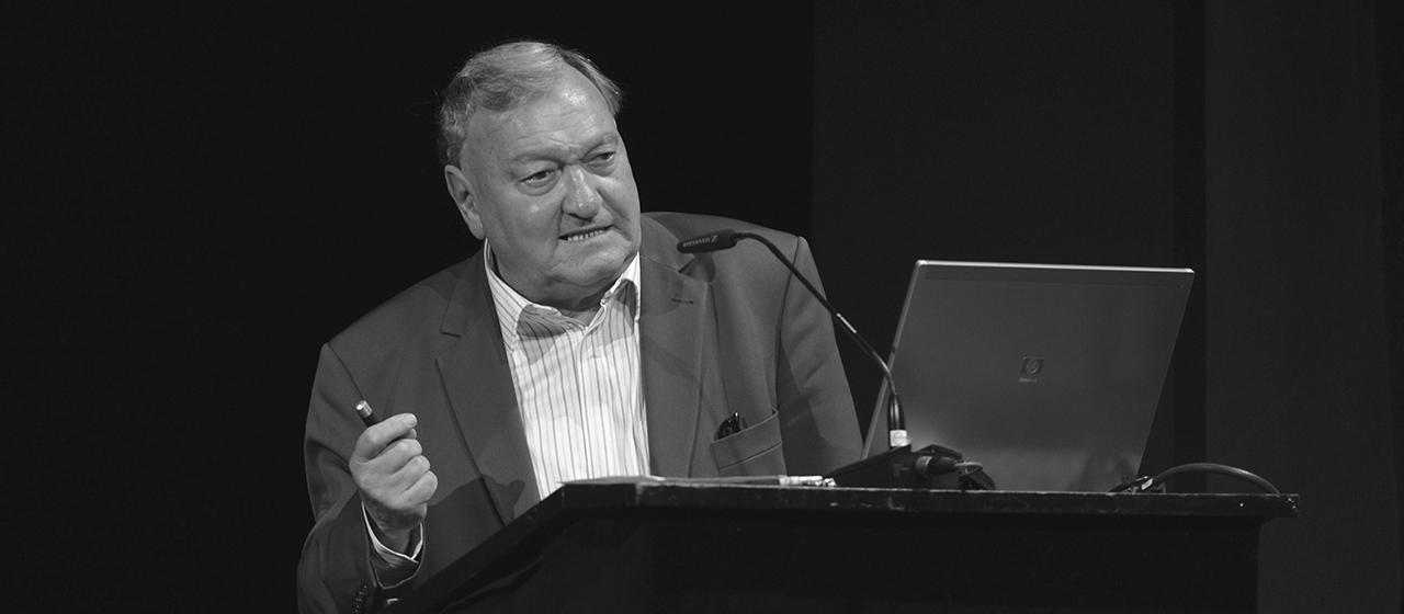 Erich von Däniken spricht an einem Rednerpult während eines Vortrages.