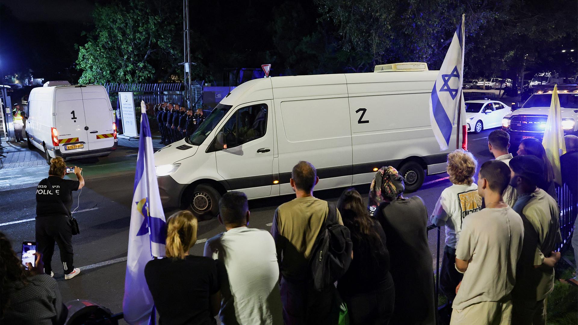 Ein Transporter mit den Körpern der verstorbenen Geiseln fährt an einem Spalier von Menschen vorbei. | REUTERS