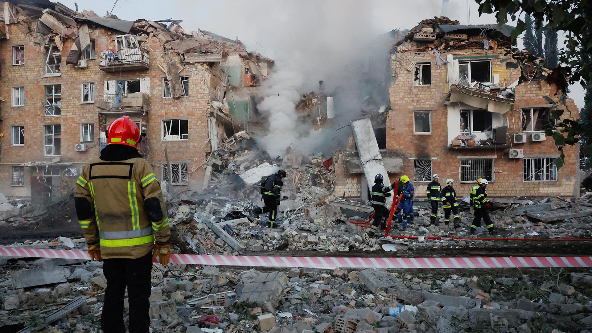 Rettungskräfte arbeiten in den Trümmern eines Wohnhauses in Kiew. | REUTERS