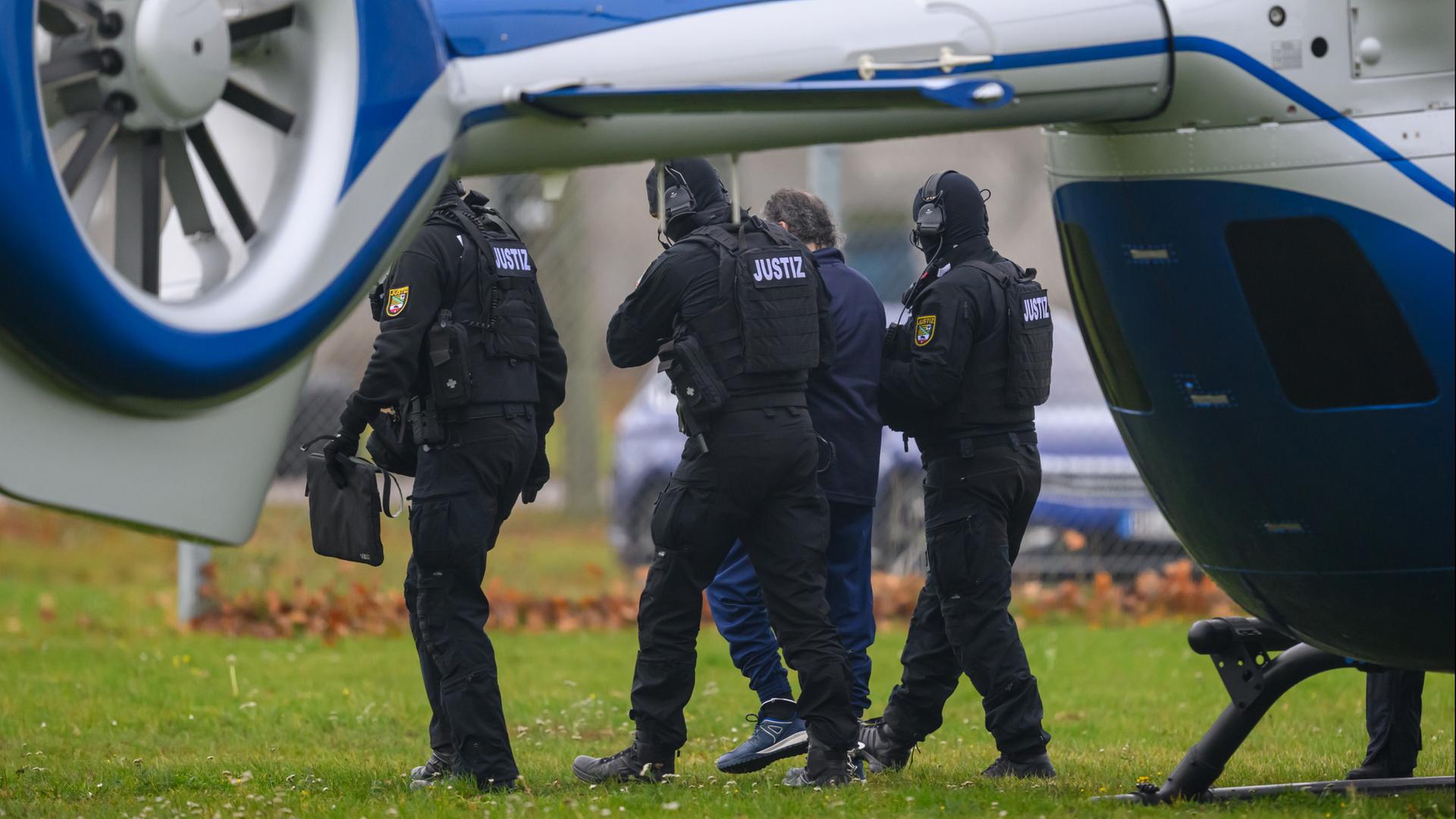 Taleb A. wird von Justizbeamten in der Nähe eines Hubschrauber geführt. | dpa