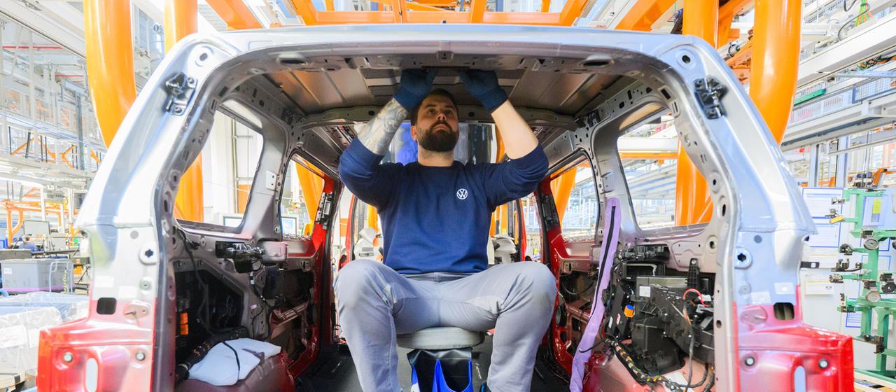  Ein Mitarbeiter montiert einem Elektro-Bullis ID Buzz im Werk Hannover
