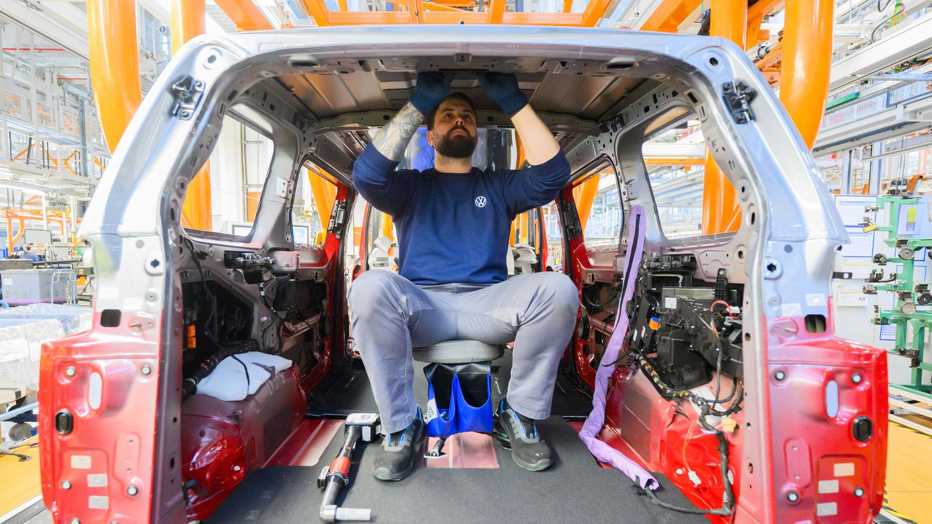  Ein Mitarbeiter montiert einem Elektro-Bullis ID Buzz im Werk Hannover | picture alliance/dpa
