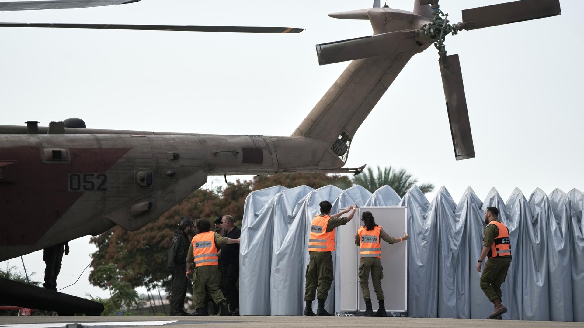  Militärangehörige richten einen Sichtschutztunnel neben einem Hubschrauber ein. | dpa