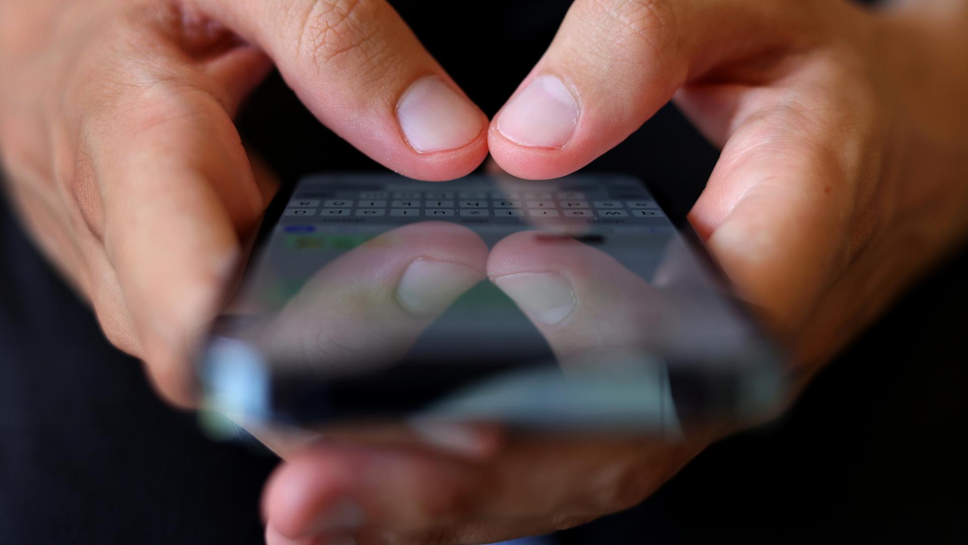 Ein Jugendlicher tippt auf einem Smartphone eine Nachricht. | dpa