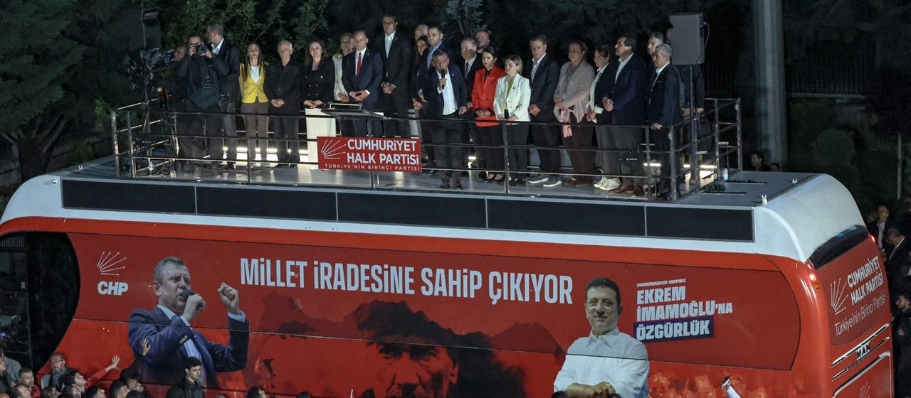 Özgür Özel steht auf einem Bus und spricht zu Demonstrierenden