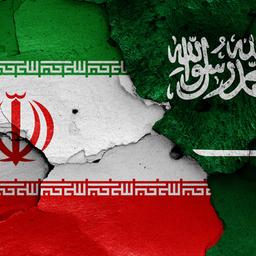 Die Flaggen von Iran und Saudi-Arabien sind auf einer gerissenen Wand aufgemalt