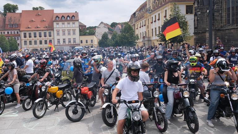 Zahlreiche Menschen versammeln sich mit ihren Simson-Mopeds auf dem Marktplatz von Wei&szlig;enfels, Sachsen-Anhalt.