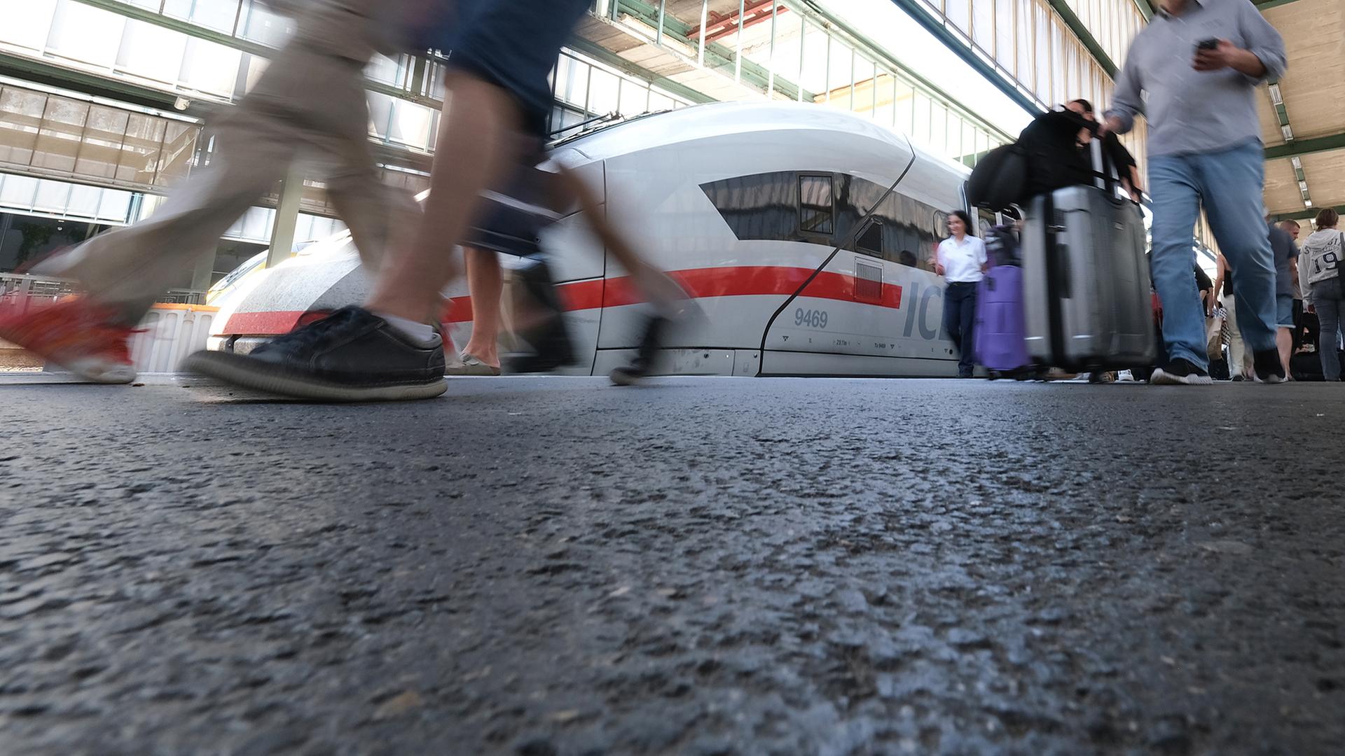 Reisende gehen auf einem Bahnsteig im Hauptbahnhof zu einem ICE Zug der Deutschen Bahn.  | dpa