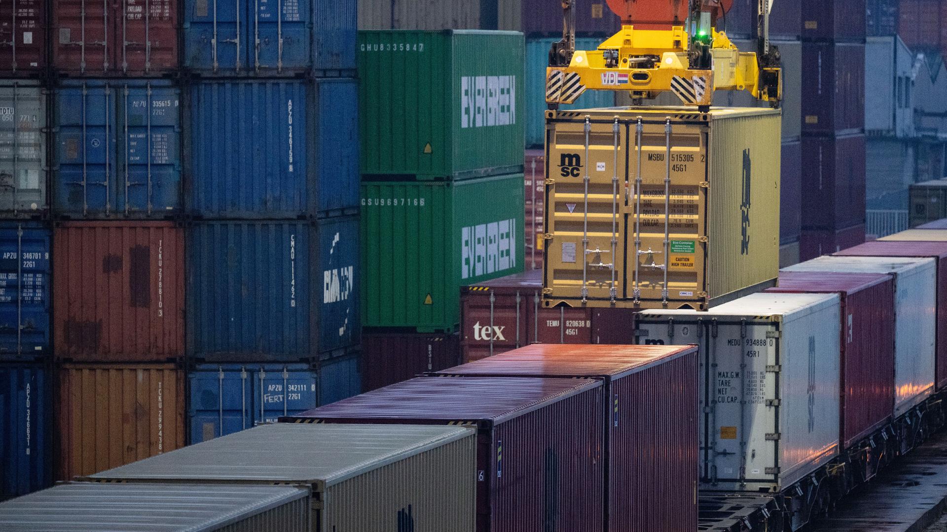 Ein Container wird von einem Kran auf einen Güterzug geladen. | dpa