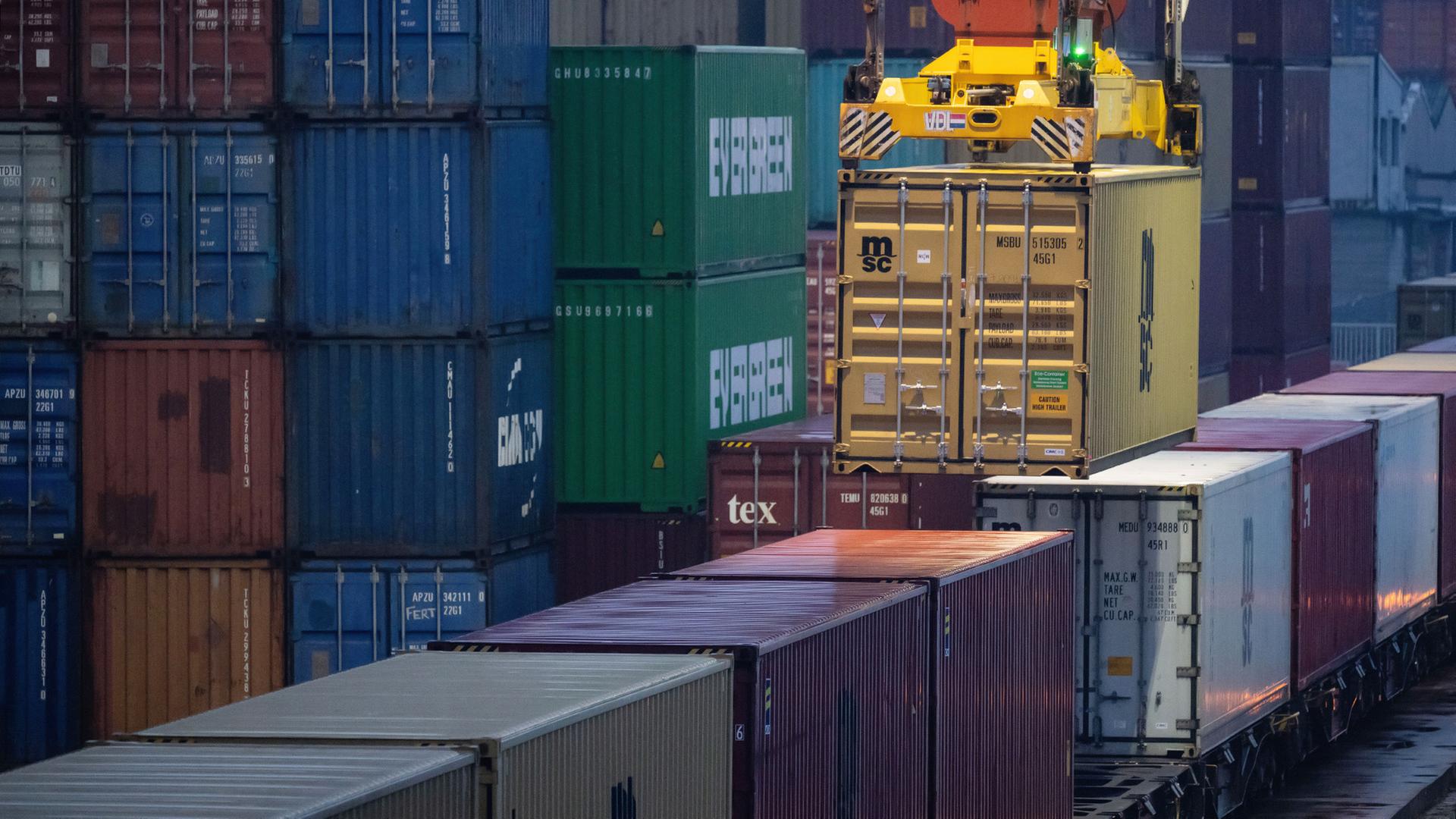 Ein Container wird von einem Kran auf einen Güterzug geladen. | dpa