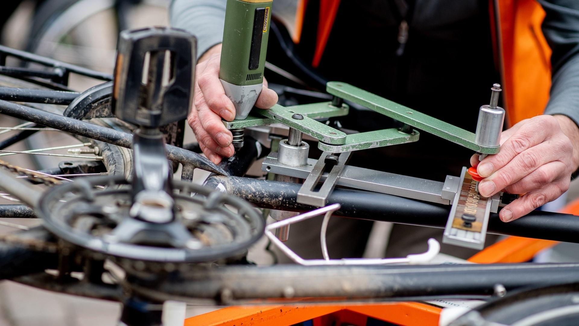 Ein Mitarbeiter des Allgemeinen Deutschen Fahrrad-Club (ADFC) codiert ein Fahrrad, um es vor Diebstahl zu schützen.  | dpa Bildfunk, picture alliance/dpa | Hauke-Christian Dittrich