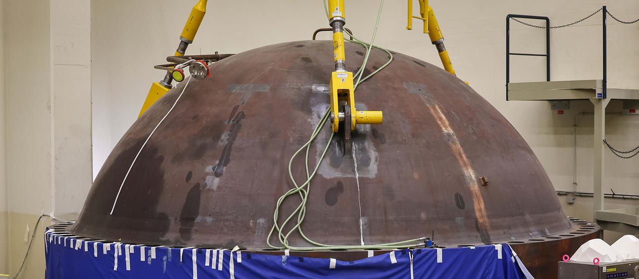 Der Deckel des geöffneten Reaktordruckbehälters lagert während des Rückbaus in einer Ecke des Reaktorgebäudes.