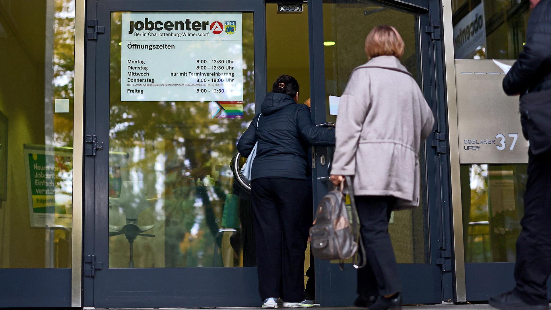 Menschen gehen in ein Jobcenter. | REUTERS