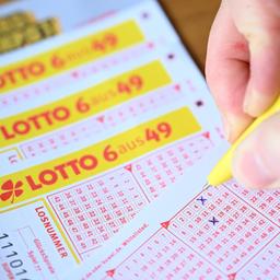 Eine Frau füllt einen Lottoschein aus.