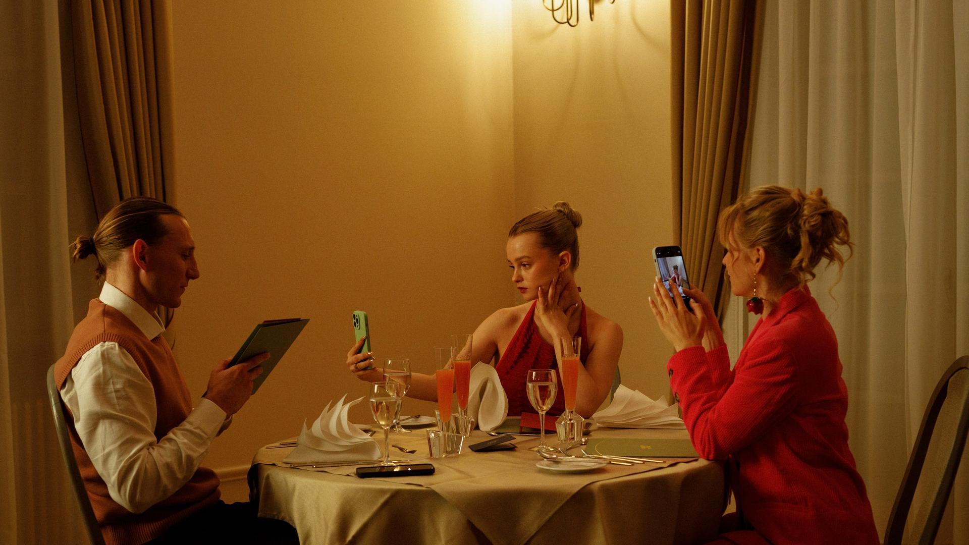 Filmszene: Eine Familie am Tisch, alle haben ein Smartphone in der Hand. | Jakob Fliedner/Across Nations