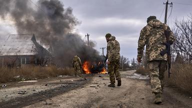 Auf diesem von der ukrainischen 10. Gebirgsjägerbrigade «Edelweiß» zur Verfügung gestellten Foto gehen ukrainische Soldaten an einem Bus vorbei, der nach Drohnenangriff in der Nähe von Bachmut in der Region Donezk brennt. 