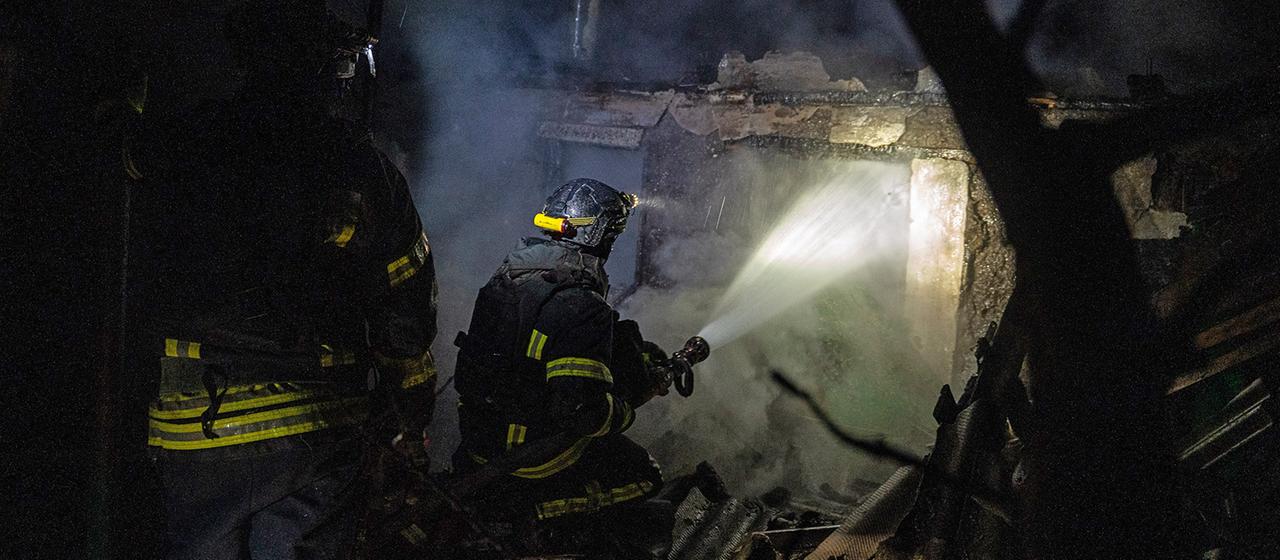 Ukrainische Feuerwehrleute löschen ein Feuer in einem Privathaus, das von einer russischen Drohne getroffen wurde.