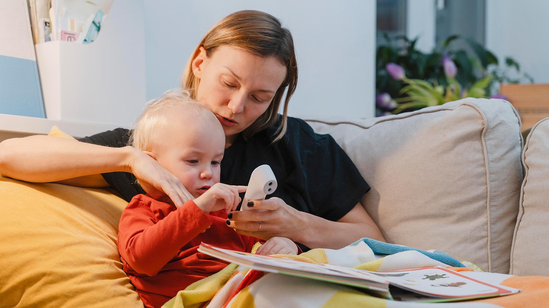 Eine Mutter sitzt mit ihrem Kind auf dem Sofa. | picture alliance / Westend61