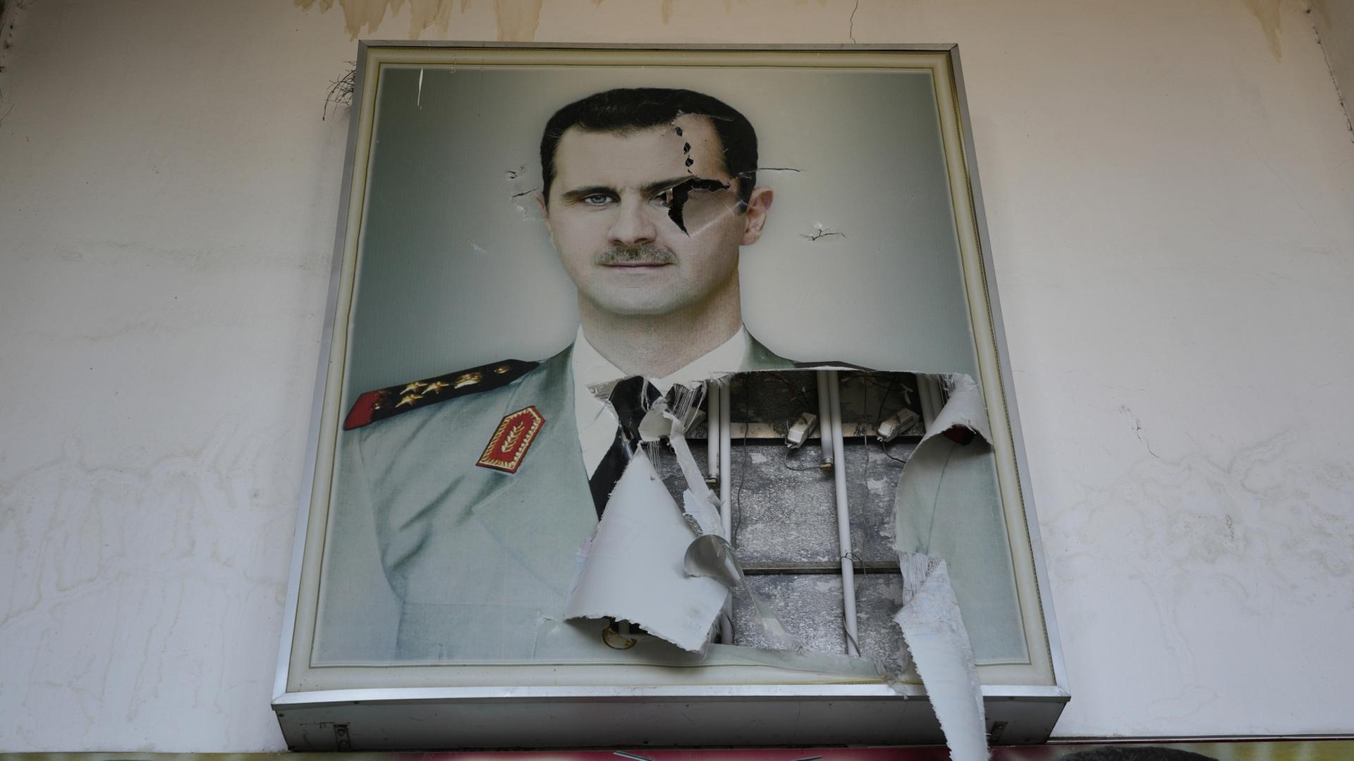 Damaskus: Ein zerrissenes Plakat zeigt den gestürzten syrischen Präsidenten Baschar al-Assad. | dpa