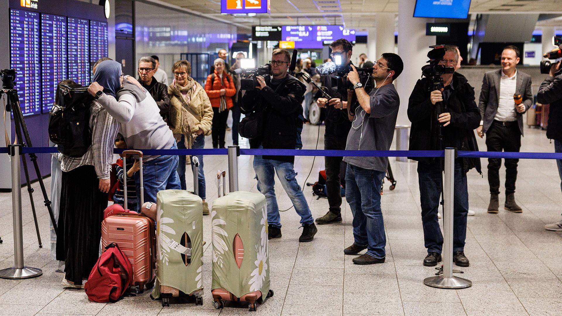 Menschen begrüßen sich nach ihrer Ankunft am Frankfurter Flughafen. | Hannes P. Albert/dpa